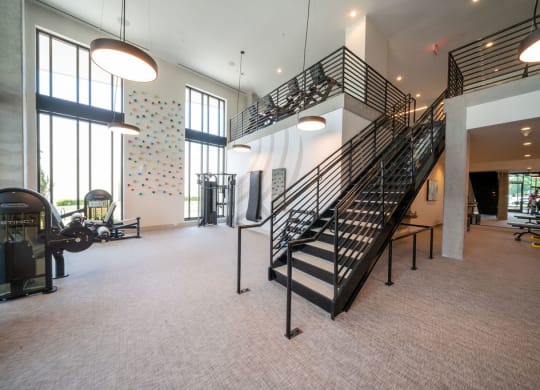 the lobby of a gym with a spiral staircase