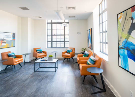 a living room with orange chairs and a table