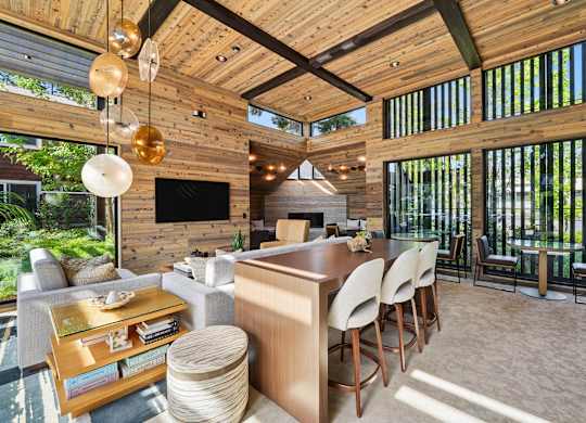 A modern living room with a wooden ceiling and a glass table.