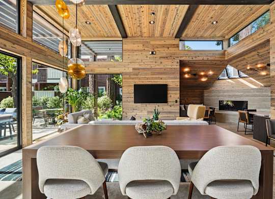 A modern dining room with a wooden table and chairs.