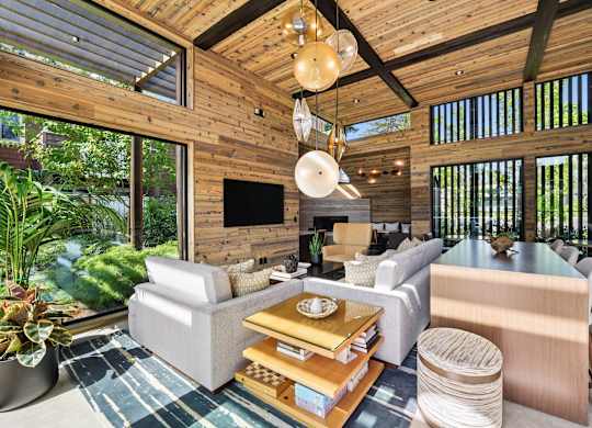 A living room with a wooden ceiling and a flat screen TV.