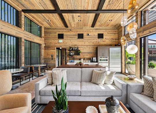A modern living room with a wooden ceiling and a large grey sofa.
