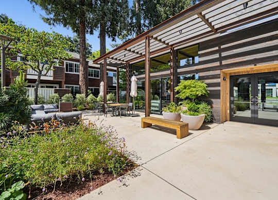 A wooden bench with a planter on it sits in front of a building.