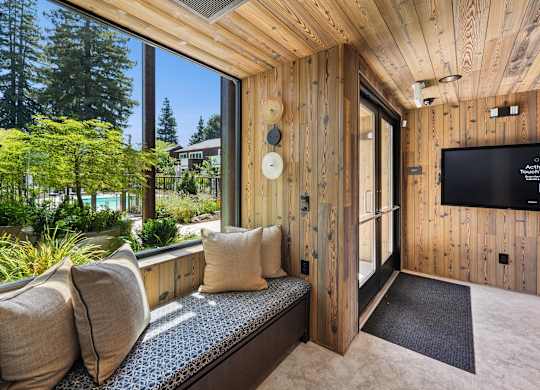 A room with a wooden wall and a window seat.