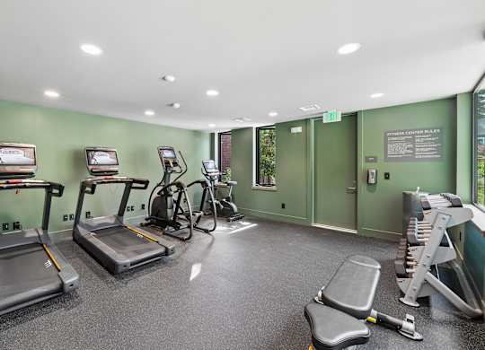 A gym with treadmills, exercise bikes, and weight machines.