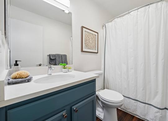 A bathroom with a white sink and a white toilet.