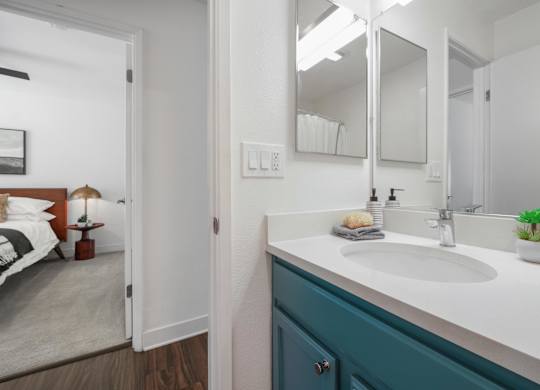 A bathroom with a white sink and a mirror above it.
