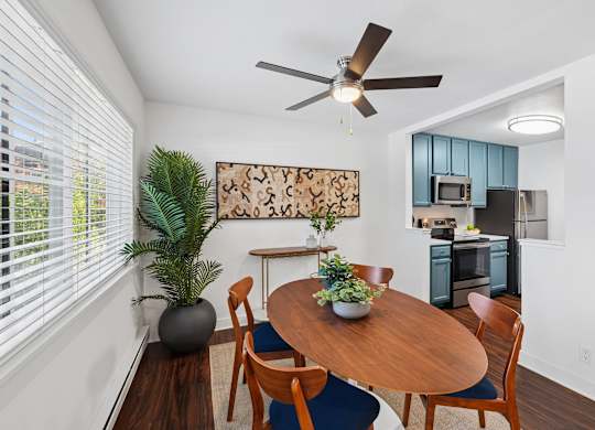 A dining room with a wooden table and chairs.