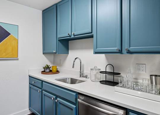 A kitchen with blue cabinets and a white countertop.