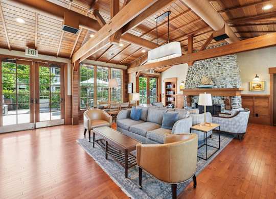 A living room with a stone fireplace and wood floors.