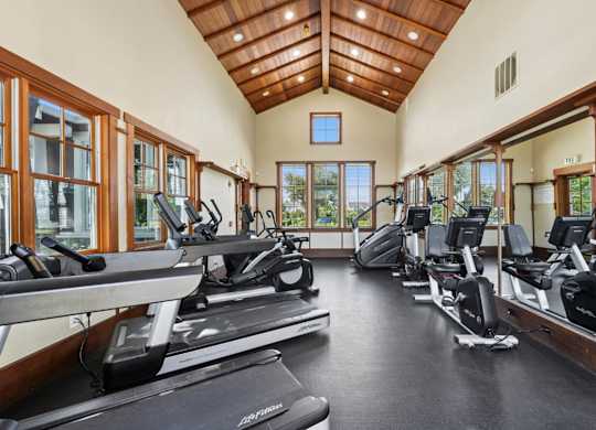 Gym with treadmills, ellipticals, and bikes at Pescadero Apartments in Redwood City