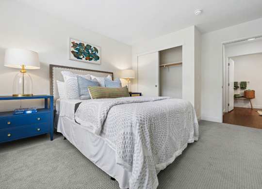 Bright bedroom at Pescadero Apartments with soft finishes, plush carpeting, and spacious closet storage.