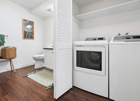 In-home washer and dryer at Pescadero Apartments with spacious utility and bathroom area.