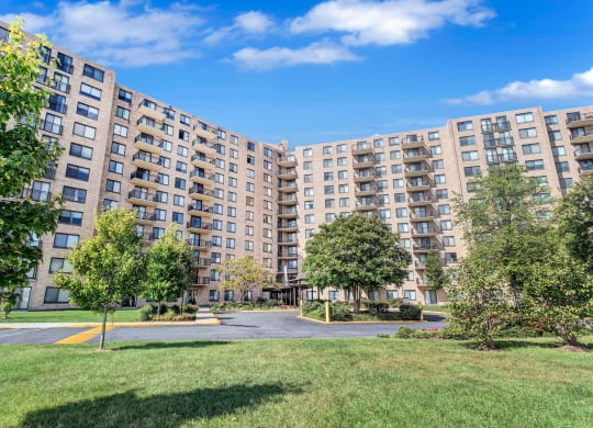 a view of a large apartment complex with grass and trees