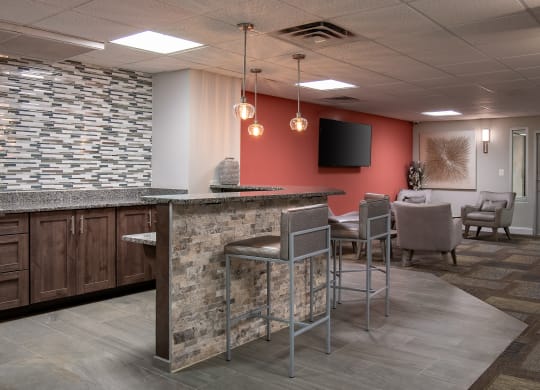 a lobby with a bar and chairs and a television