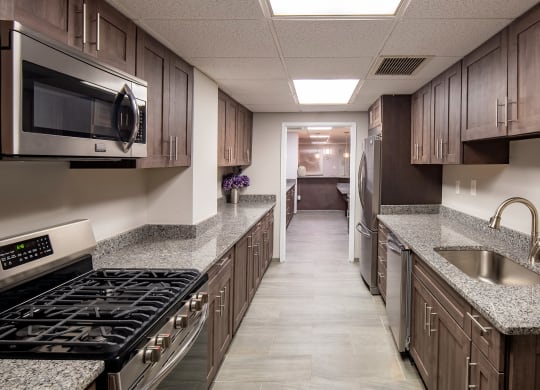 a kitchen with granite counter tops and wooden cabinets