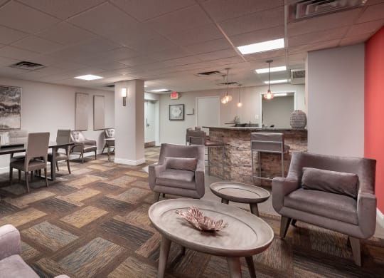 a lounge area with chairs and tables and a reception desk