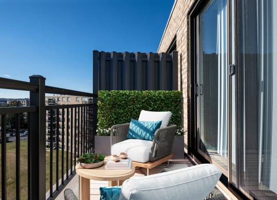 a balcony with two chairs and a table and a window