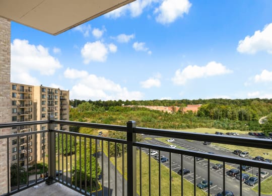 the view from the balcony of an apartment building overlooking a parking lot