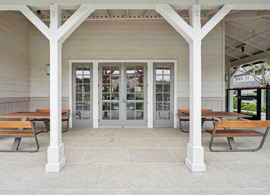 Covered outdoor seating area with table and pool views