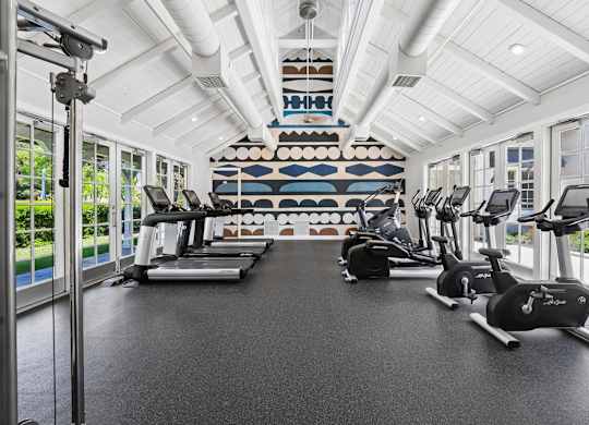 Fitness center with treadmills, stationary bikes, and strength equipment at The Presidio Apartments
