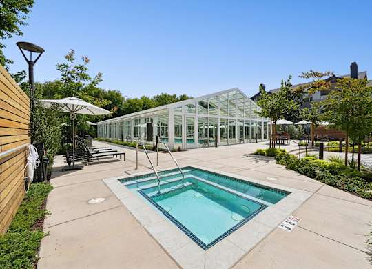 Outdoor hot tub in landscaped courtyard at The Presidio Apartments