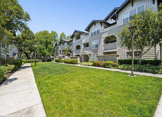 A row of houses with a green lawn in front.