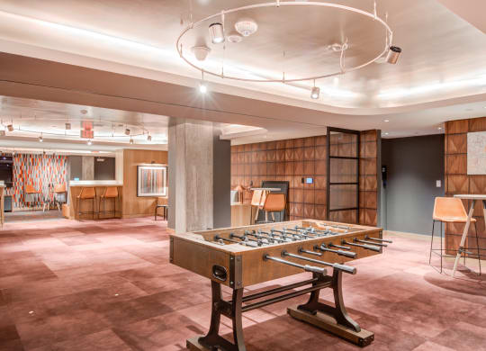 a large room with a foosball table and a bar