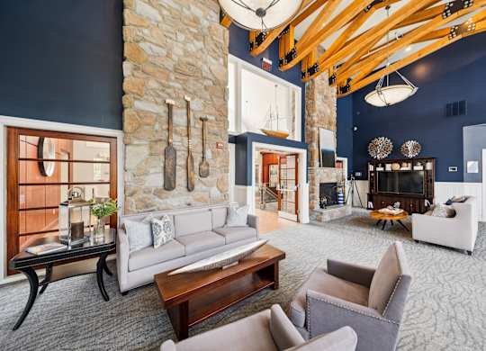 A living room with a stone wall and a fireplace.
