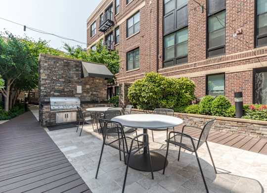 Image showing Outdoor grill station with stainless steel grills and modern seating area.