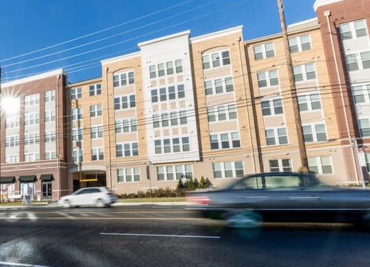 a large brick building with cars driving in front of it