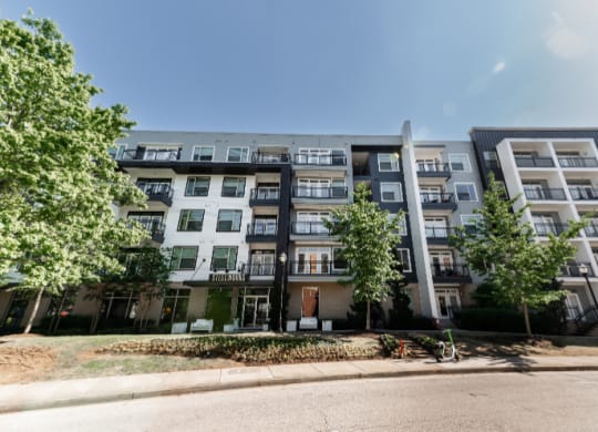 an apartment building on a street with trees in front of it