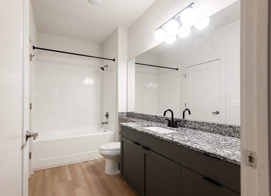 A bathroom with a sink, mirror, and toilet.