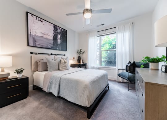 a bedroom with a large bed and a ceiling fan