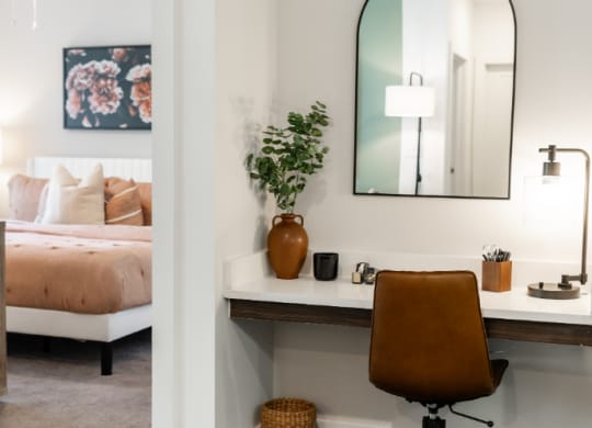 a desk with a mirror and a chair in a bedroom