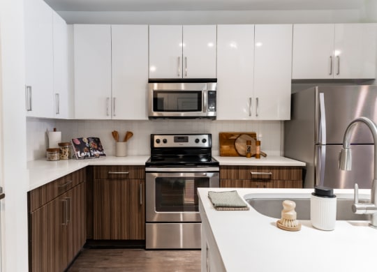 a modern kitchen with stainless steel appliances and white cabinets