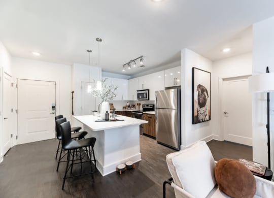a kitchen with a white counter top and a stainless steel refrigerator