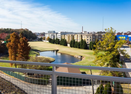 a view of a golf course and a pond from a balcony