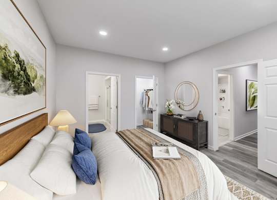 a white bedroom with a bed and a mirror