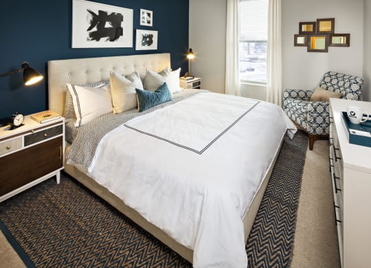 a bedroom with a large white bed and a blue accent wall