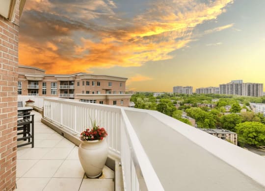 a balcony with a view of the city at sunset