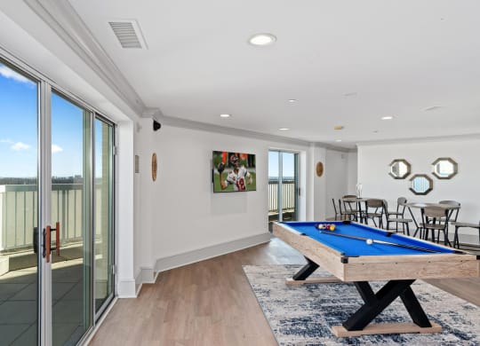 a living room with a pool table and a balcony