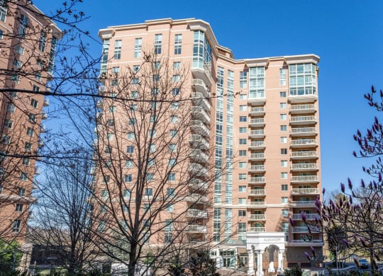 a large apartment building in a city with trees in the foreground