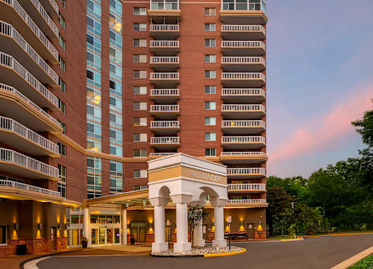 A large hotel with a white entrance and balconies.