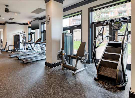 A gym with treadmills, elliptical machines, and other exercise equipment.