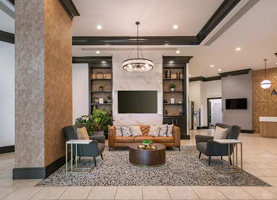 A modern living room with a large sofa, a coffee table, and a TV.