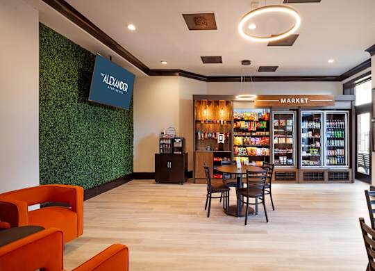 A modern cafe with a green wall and a market section.