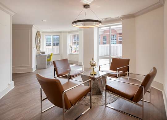 A living room with brown leather chairs and a round table.