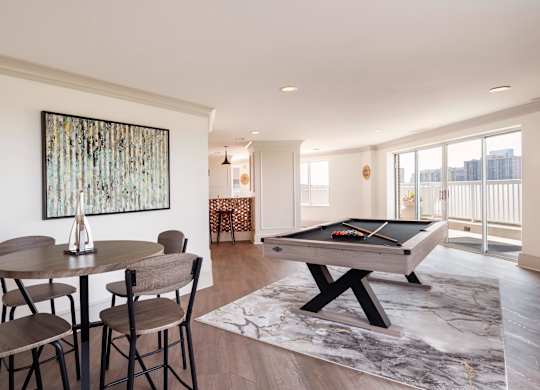 A room with a pool table and a painting on the wall.