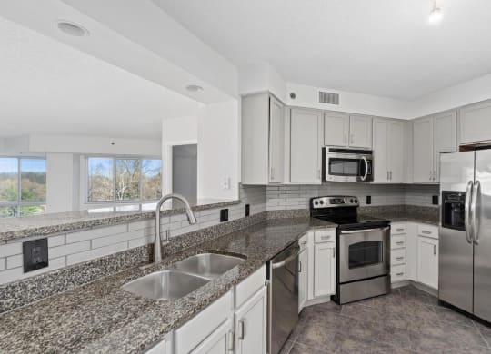 a kitchen with granite counter tops and stainless steel appliances